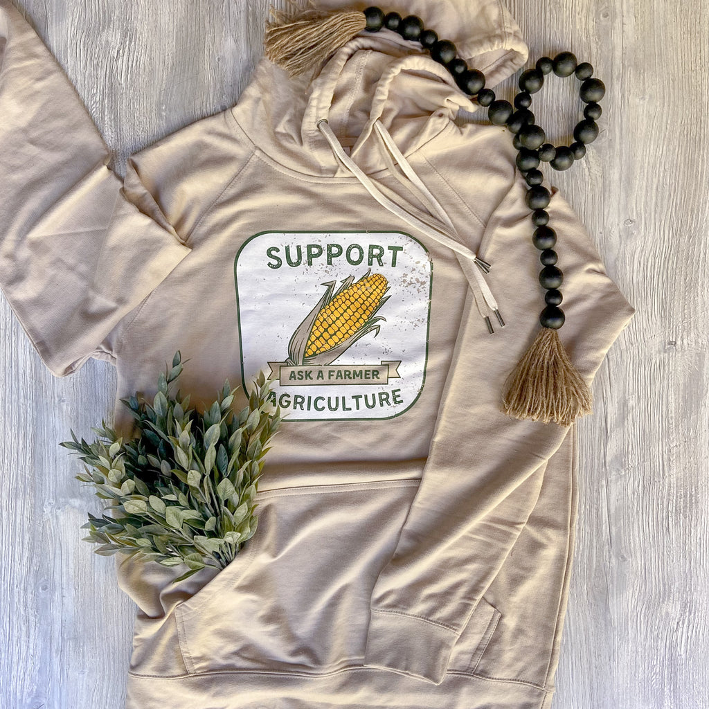 Tan hoodie that says support agriculture on it with a corn cob in the middle. Ask a Farmer