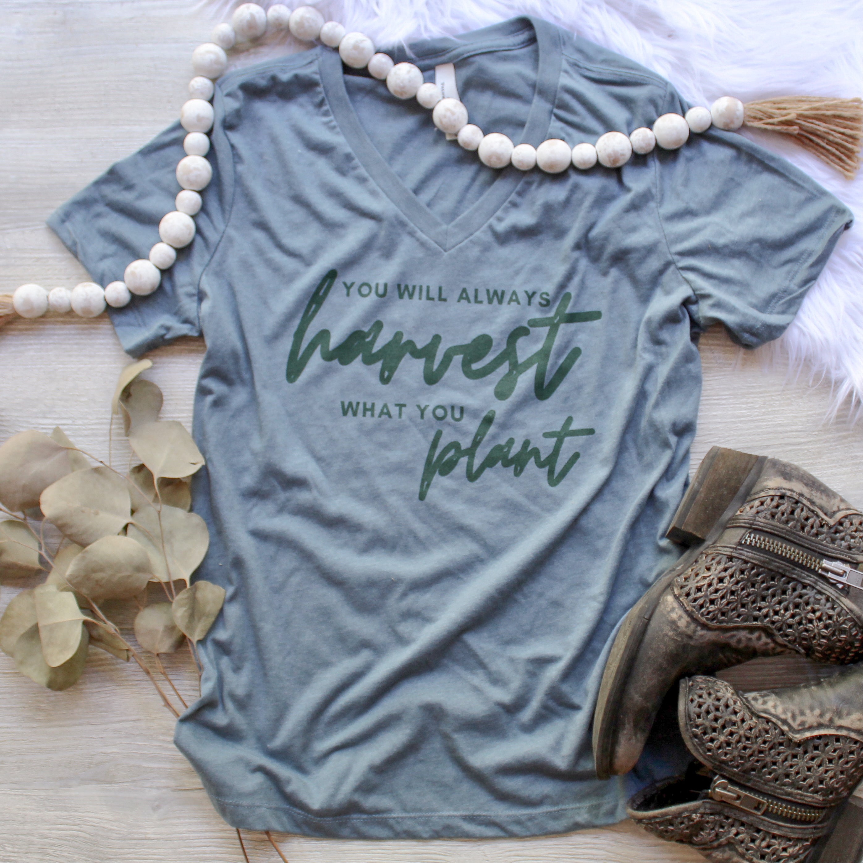 Teal vneck tshirt that says you will always harvest what you plant on it.