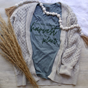 Teal vneck tshirt that says you will always harvest what you plant on it.
